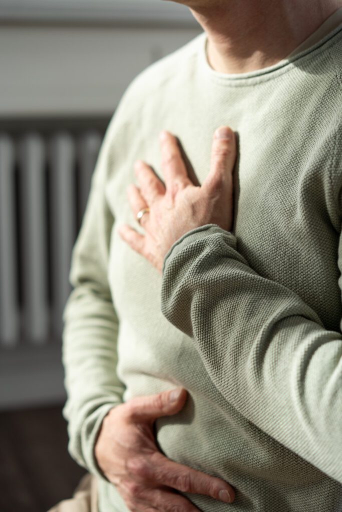 Jan Wolk leitet gerade eine Achtsamkeitspraxis im Rahmen des Yin Yoga Retreats in Hamburg an. Er hat eine Hand auf dem Herzen und die andere Hand auf dem Bauch. 